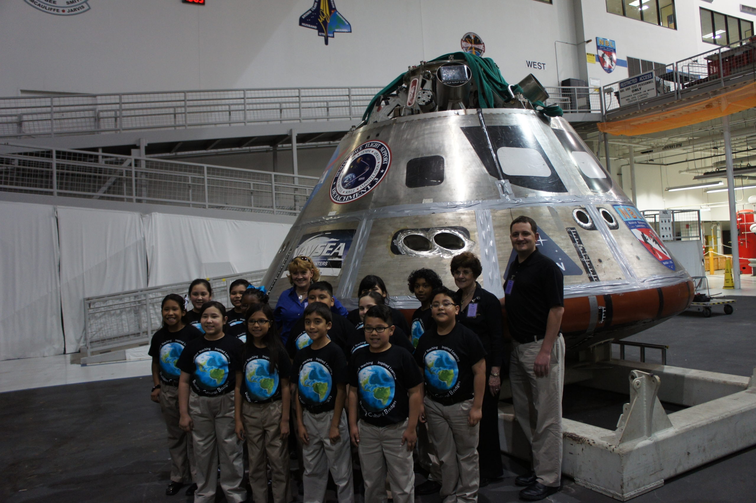 Building Cultural Bridges choir posing for a picture in front of the NASA Artemis capsule. 